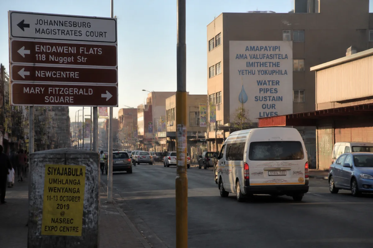 Scène urbaine sud-africaine avec signalétique multilingue, sans identification de l’origine des personnes